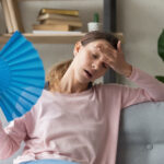 Overheated,Millennial,Woman,Sit,On,Couch,At,Home,Feel,Warm